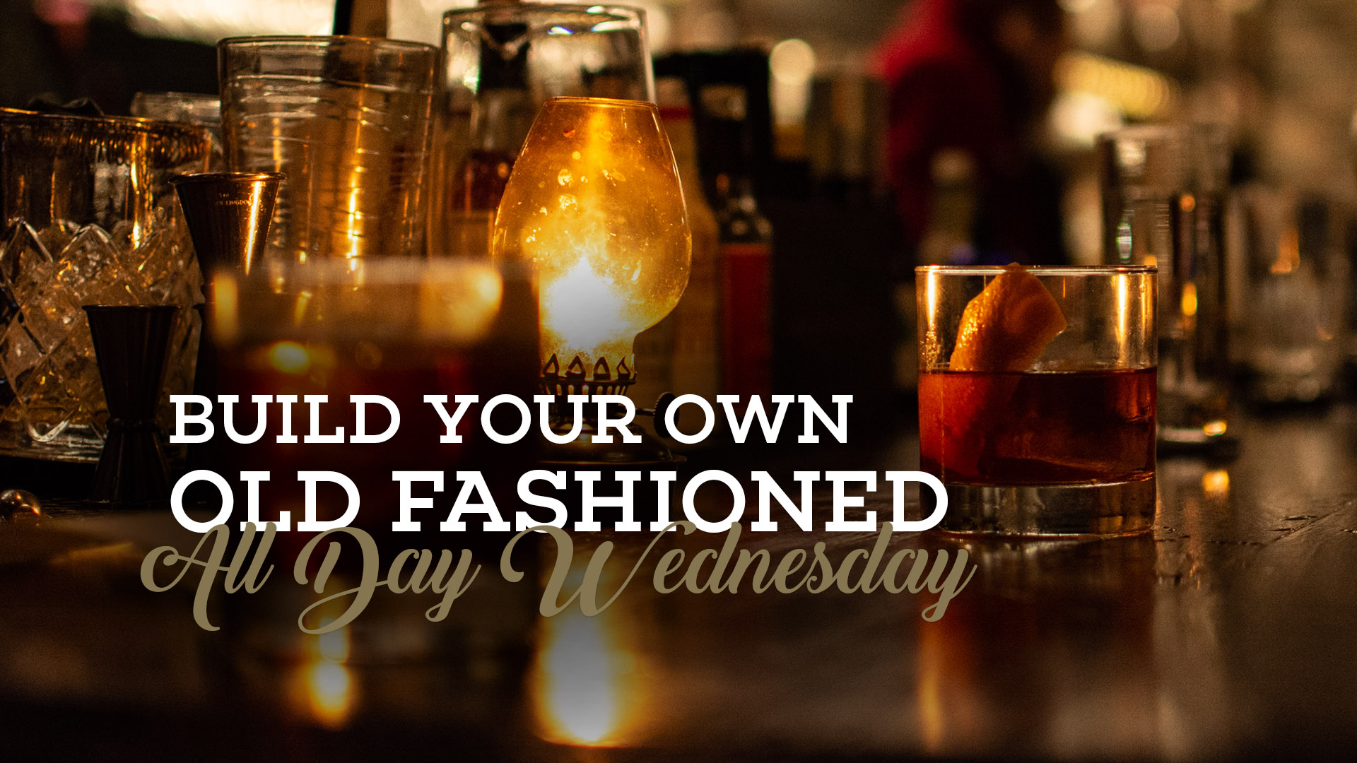 Picture of an old fashioned cocktail on top of the bar at Bottled in Bond Cocktail Parlour and kitchen. The text on top of the picture says Build Your Own Old Fashioned All Day Wednesday.