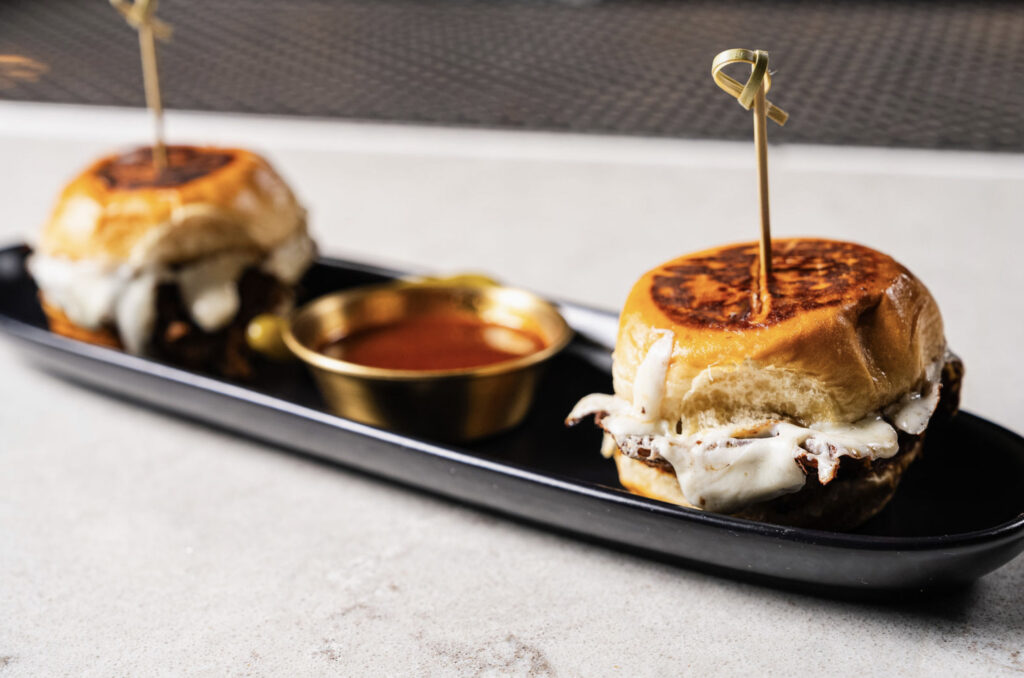 Birria Sliders with dipping sauce at Bottled in Bond Cocktail Parlour and Kitchen