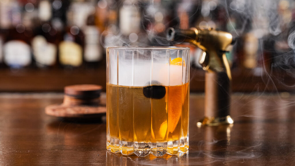 Bartender making a smoked cherry cocktail